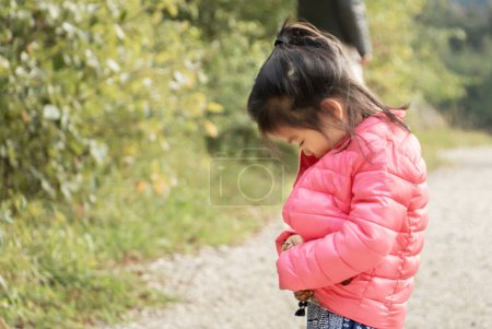 Photo for Little Eurasian Girl - French and Chinese - Learning to Close Her Jacket on Her Own - Learning to Live - Becoming Independent - Royalty Free Image