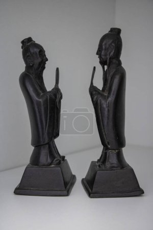 Téléchargez les photos : Bonze prêtres bouddhistes chinois priant 2 Statuettes chinoises noires en bronze face à face sur fond blanc Statues antiques - en image libre de droit