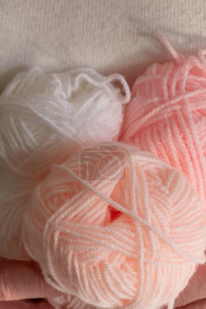 Téléchargez les photos : 3 boules de fil tenues dans les mains d'une femme couleur pastel doux pour tricoter layette - en image libre de droit