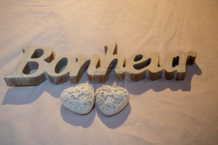 Foto de 2 corazones de cerámica y la palabra felicidad (Bonheur en francés) grabada en madera - Imagen libre de derechos