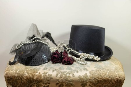 Foto de Elegantes accesorios de moda sombreros, collar de perlas y rosa para boutonniere, sombrero de copa y velo fascinador sombrero - Imagen libre de derechos