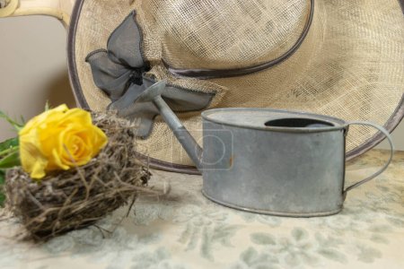Téléchargez les photos : Retour du printemps, chapeau de paille rose jaune avec nid d'oiseau et arrosoir pour aller au jardin - en image libre de droit