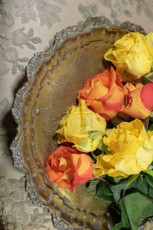 Foto de Flat lay 6 rosas naranjas y amarillas colocadas en una bandeja de cobre - Imagen libre de derechos