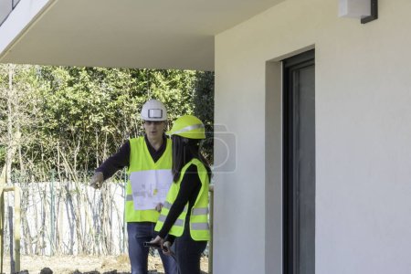 Téléchargez les photos : Homme et femme, travailleur de la construction en visite sur place, avec leurs vêtements de sécurité - en image libre de droit