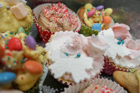 Téléchargez les photos : Assortiment de différents cupcakes, glaçages différents, décorations différentes, perles de sucre, guimauve, glaçage royal, crème, bonbons au chocolat, couverture et sculpture en pâte à sucre - en image libre de droit