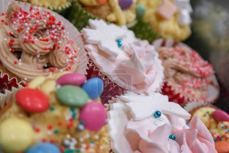 Téléchargez les photos : Variété de cupcakes très colorés décorés avec des bonbons et de la pâte à sucre garniture en gros plan - en image libre de droit