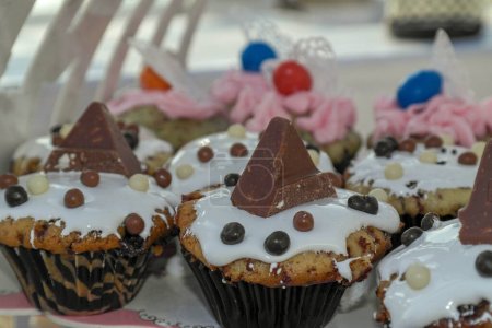 Téléchargez les photos : Assortiment de cupcakes au chocolat avec un morceau de barre de chocolat en forme de pyramide, sur un stand de gâteau - en image libre de droit