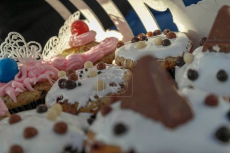 Téléchargez les photos : Assortiment de cupcakes sur porte-gâteaux, avec glaçage royal, pépites de chocolat et dentelle de sucre. - en image libre de droit