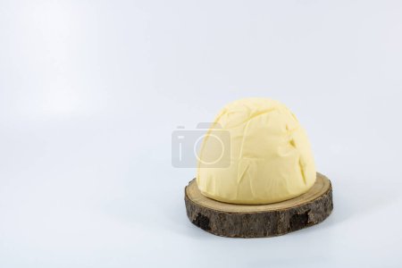 Auf einem hölzernen Tablett vor weißem Hintergrund wurde Butter mit salzigem Geschmack aufgewirbelt und geformt.