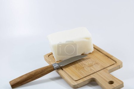 lard block with a knife planted in wooden cutting board
