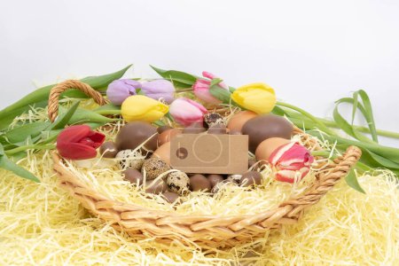 Photo for Label, chocolate eggs, quail eggs and chicken eggs and tulips for Easter - Royalty Free Image