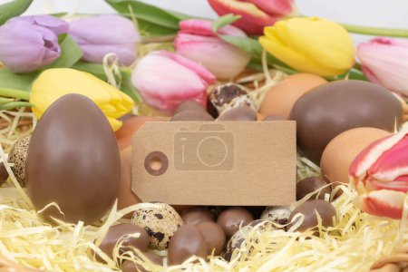  label, chocolate eggs, quail eggs and chicken eggs and tulips for Easter