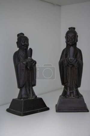 2 chinesische schwarze Bronzestatuetten Gesicht auf weißem Hintergrund, ausgeschnittene Objekte