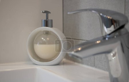 Distributeur de savon liquide à bulles, blanc sur une jante de lavabo, objet découpé