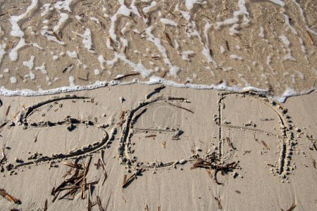 Foto de Onda borrando la palabra mar escrita en la arena a la playa - Imagen libre de derechos