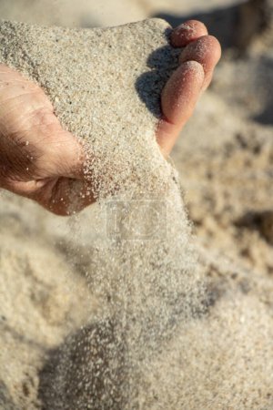 Foto de Hombre principal lanzando un puñado de arena concepto de pasar el tiempo cosas que escapan de nosotros - Imagen libre de derechos