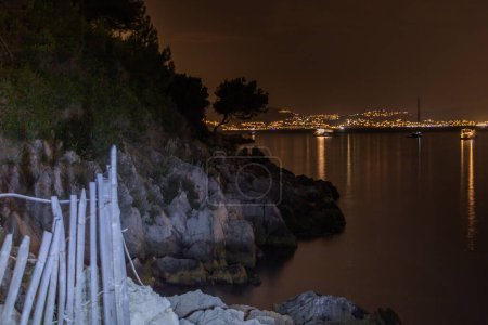 Téléchargez les photos : Photo de nuit avec peinture sur l'île de Saint Honorat Lrins Cannes Côte d'Azur Provence Alpes Maritimes France avec vue sur la baie de Cannes et les lumières de Mandelieu la Napo - en image libre de droit