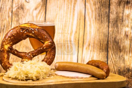 Foto de Oktober Fest con un vaso de cerveza un pretzel gigante y un chucrut adornado en plato de madera - Imagen libre de derechos