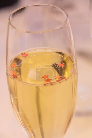 Téléchargez les photos : Flûte à champagne remplie de champagne aux paillettes rouges en forme d'étoile, flûte à champagne remplie de champagne aux paillettes rouges en forme d'étoile - en image libre de droit