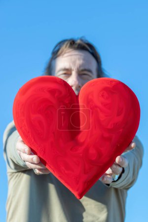 Téléchargez les photos : Homme tenant un énorme cœur rouge devant lui - en image libre de droit