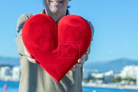 Téléchargez les photos : Homme tenant un énorme cœur rouge devant lui - en image libre de droit