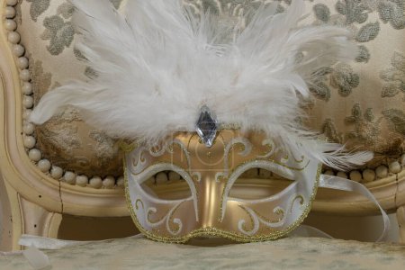Foto de Media máscara de dominó de oro y pluma blanca, estilo rococó para el carnaval - Imagen libre de derechos