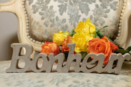 Carved in the wood, the word happiness on a bergere gray fabric, shabby chic, and bouquet of roses