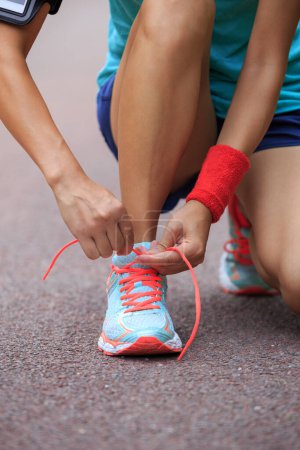 Photo for Young woman runner tying shoelaces - Royalty Free Image