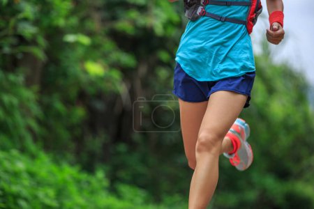 Foto de Joven fitness mujer trail runner corriendo en el bosque - Imagen libre de derechos