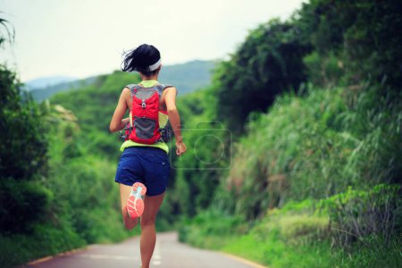 Foto de Corredor de sendero joven fitness mujer corriendo en la montaña del bosque - Imagen libre de derechos