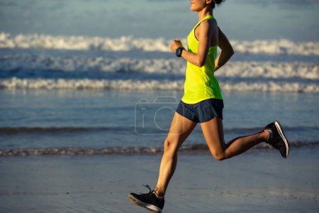 Téléchargez les photos : Mode de vie sain jeune femme fitness courir sur la plage du lever du soleil - en image libre de droit