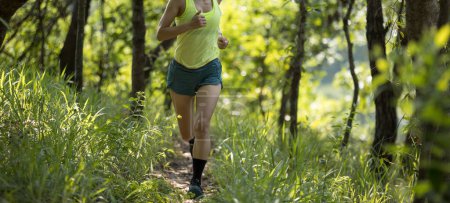 Foto de Fitness woman trail runner running in summer forest trail - Imagen libre de derechos