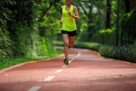 Photo for Fitness woman running on sunny tropical park trail - Royalty Free Image