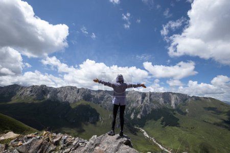 Photo for Successful woman hiking on alpine mountain peak - Royalty Free Image