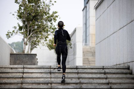 Foto de Mujer de fitness corriendo escaleras arriba en la ciudad - Imagen libre de derechos