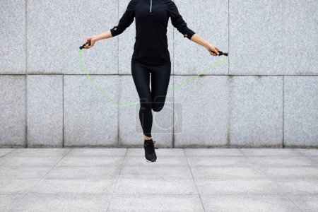 Foto de Fitness mujer cuerda saltar contra la pared de la ciudad - Imagen libre de derechos
