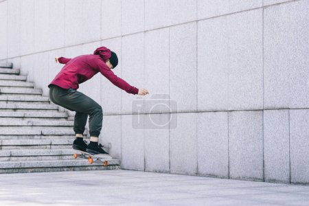 Photo for Asian woman skateboarder skateboarding in modern city - Royalty Free Image