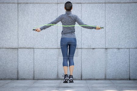 Foto de Fitness mujer cuerda saltar contra la pared de la ciudad - Imagen libre de derechos