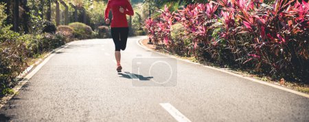 Foto de Corredor de fitness mujer corriendo en pista de parque de invierno - Imagen libre de derechos
