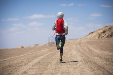 Foto de Fitness mujer trail runner cross country running en el desierto - Imagen libre de derechos