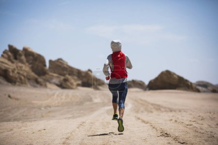 Foto de Fitness mujer trail runner cross country running en arena desierto - Imagen libre de derechos