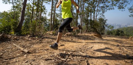 Téléchargez les photos : Woman trail runner running at tropical forest mountain peak - en image libre de droit
