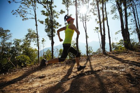 Téléchargez les photos : Woman trail runner running at tropical forest mountain peak - en image libre de droit