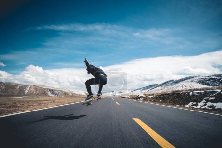 Photo for Asian woman skateboarder skateboarding on snowy  country road - Royalty Free Image