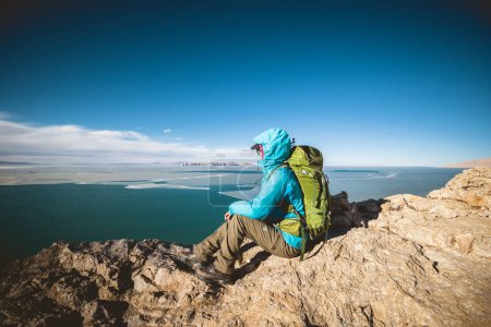 Téléchargez les photos : Femme randonneur profiter de l'ivew sur la falaise du sommet de la montagne ege au bord du lac - en image libre de droit