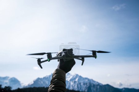 Téléchargez les photos : Drone volant dans les montagnes de neige de haute altitude - en image libre de droit
