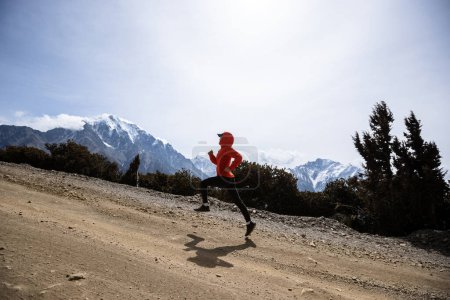 Photo for Woman trail runner cross country running on high altitude mountain trail - Royalty Free Image