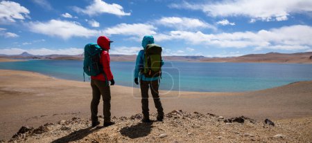 Photo for Two women backpackers hiking in beautiful winter high altitude mountains - Royalty Free Image