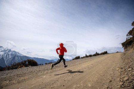 Téléchargez les photos : Femme trail coureur cross country course sur le sentier de montagne de haute altitude - en image libre de droit