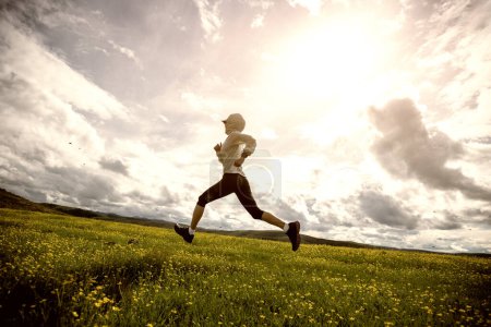Téléchargez les photos : Femme trail runner cross country courir à haute altitude prairie - en image libre de droit